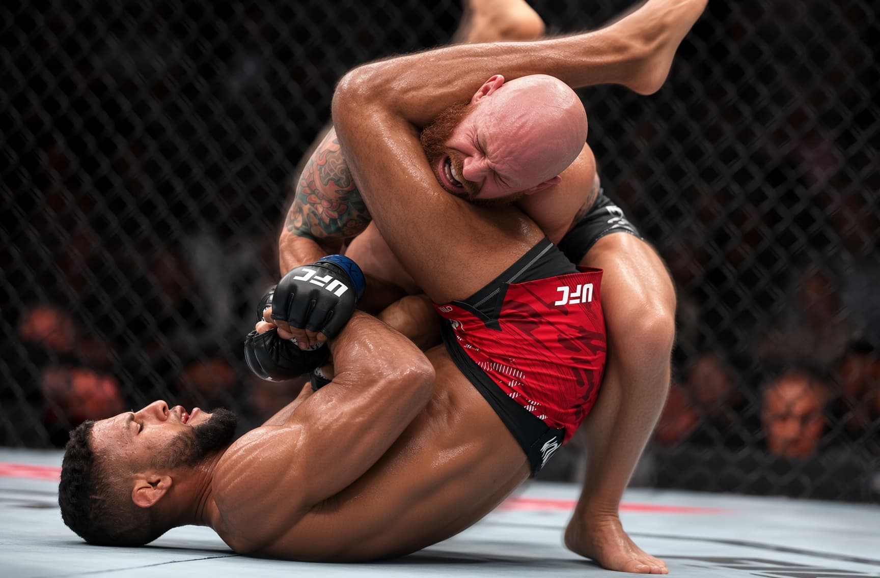 A fighter extending an armbar from guard.