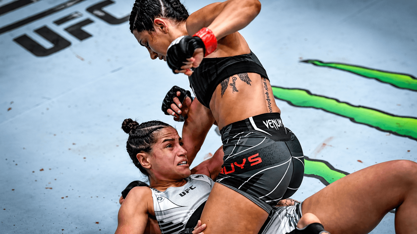 A fighter striking downward from top position on the mat.