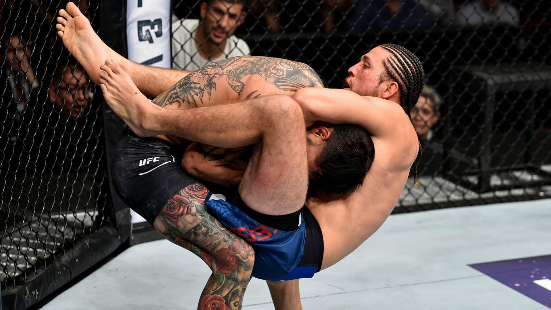 A fighter squeezing a guillotine choke.