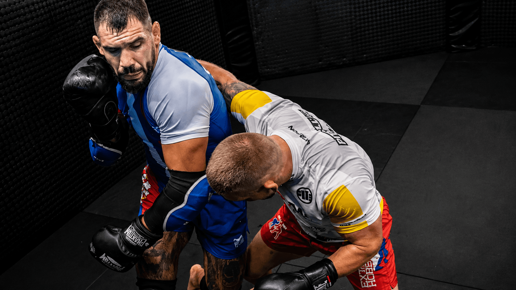 Fighters working on the mats in a gym, away from the cage.