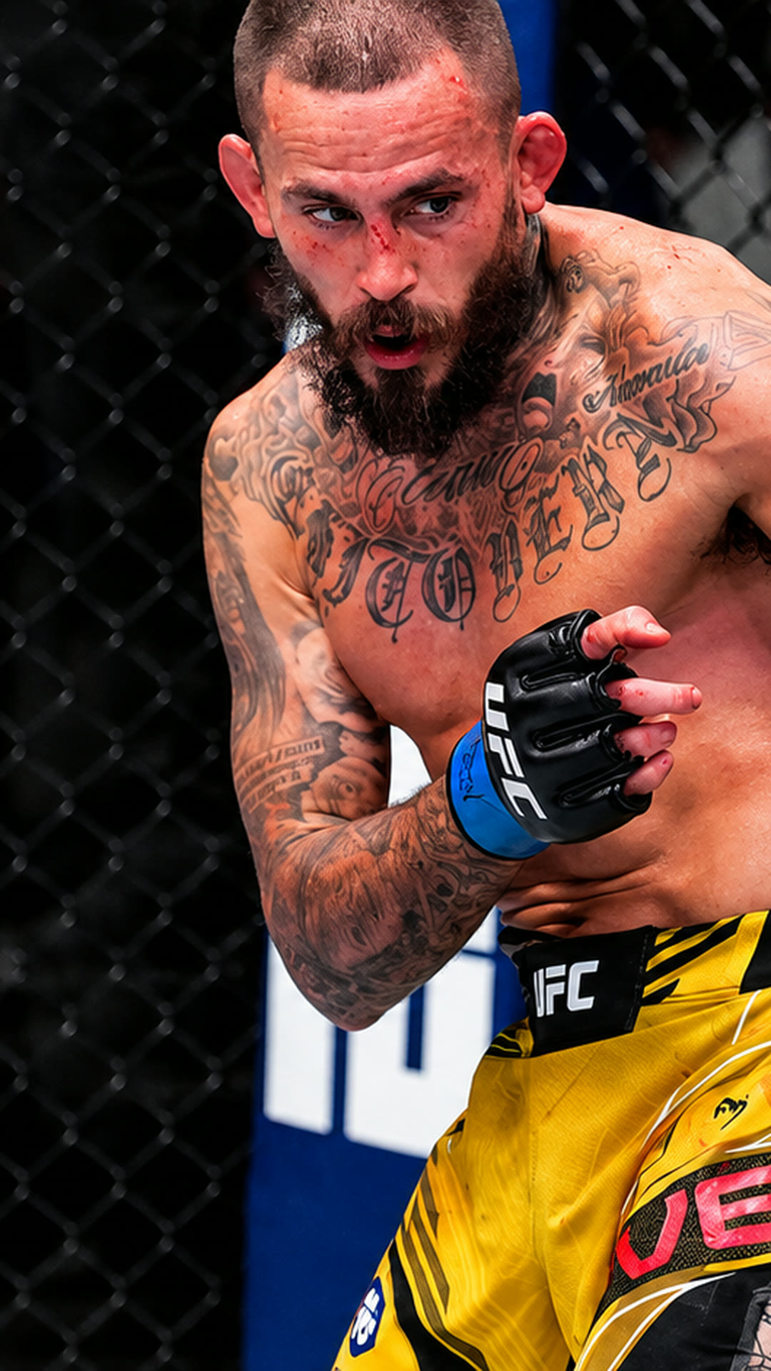 Marlon Vera, blood on his face, hands low, walking forward.